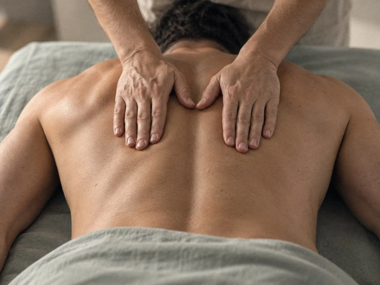 Massage du haut du dos et des trapèzes, patient allongé