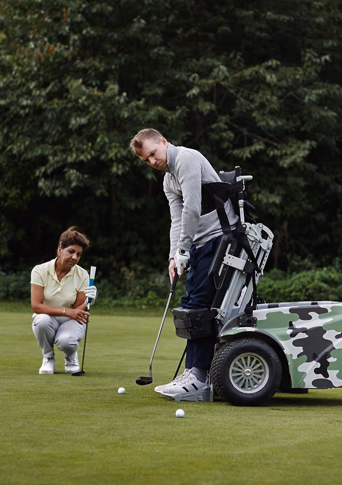 Coach kneeling beside golfer on the course