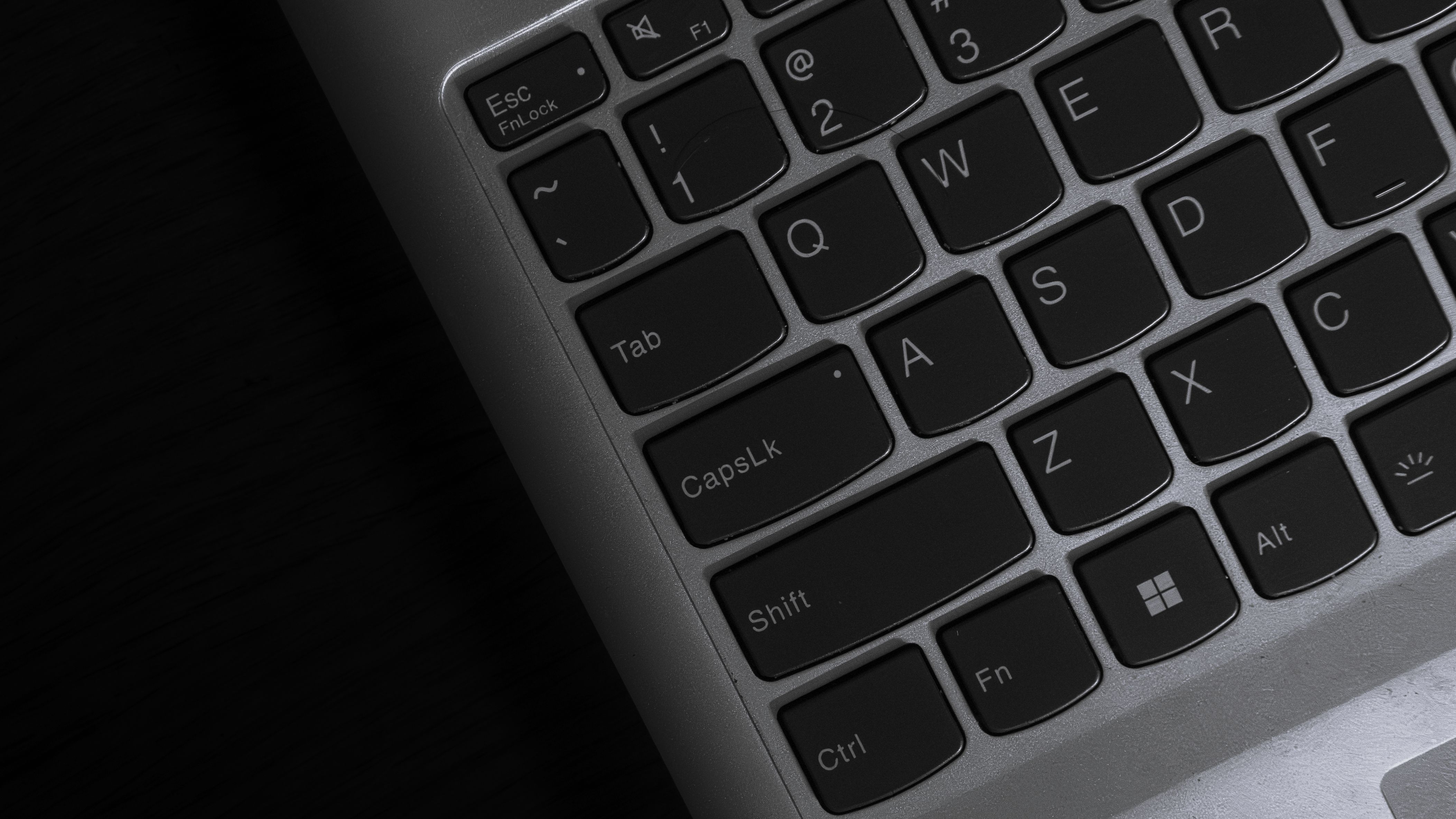 Close-up of a laptop keyboard showing keys including Esc, Tab, Caps Lock, Shift, Ctrl, Q, W, E, A, S, D, Z, X, C, Fn, Alt, and the Windows key.
