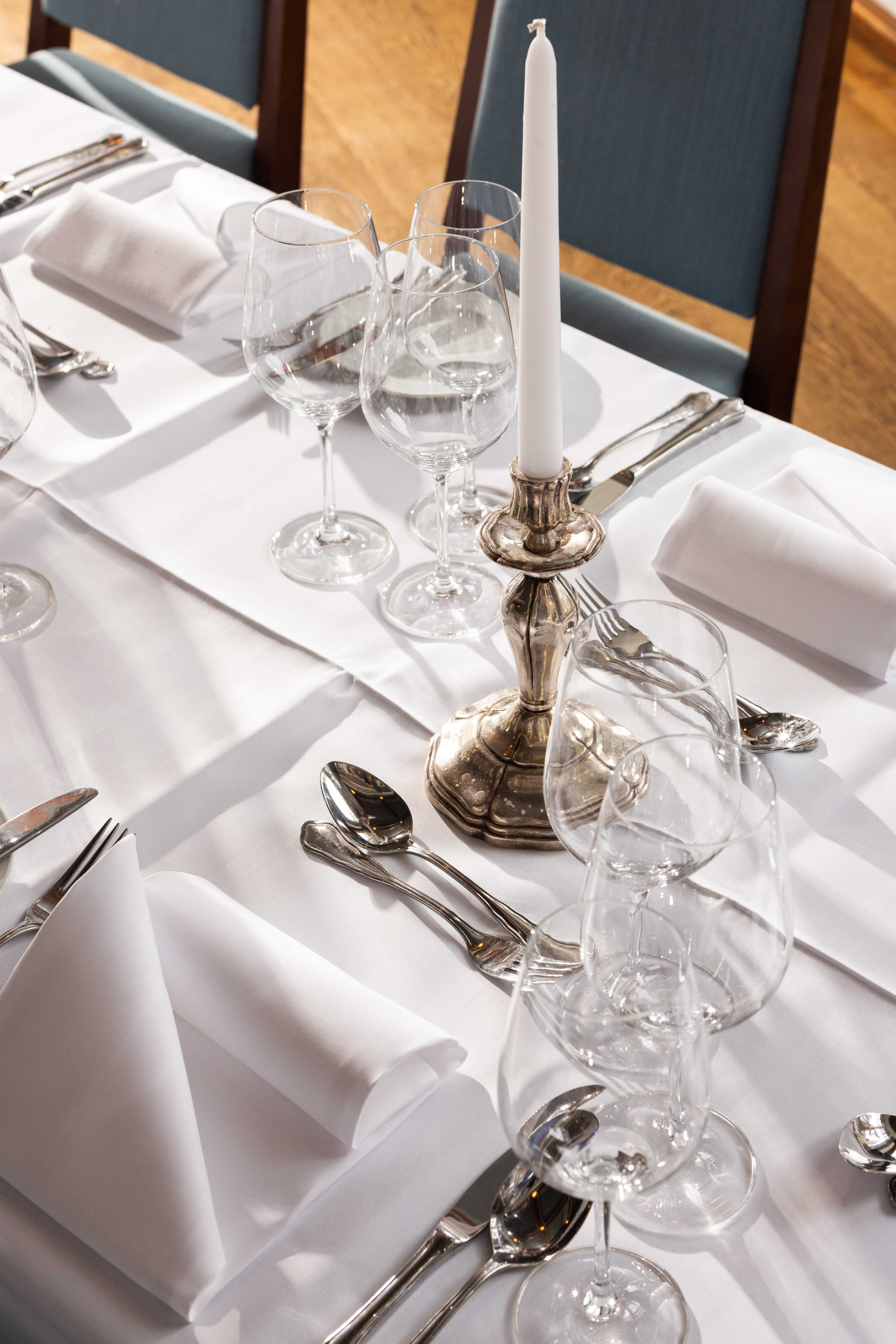 Gedeckter Tisch mit Kerzenleuchter, Gläsern und Silberbesteck