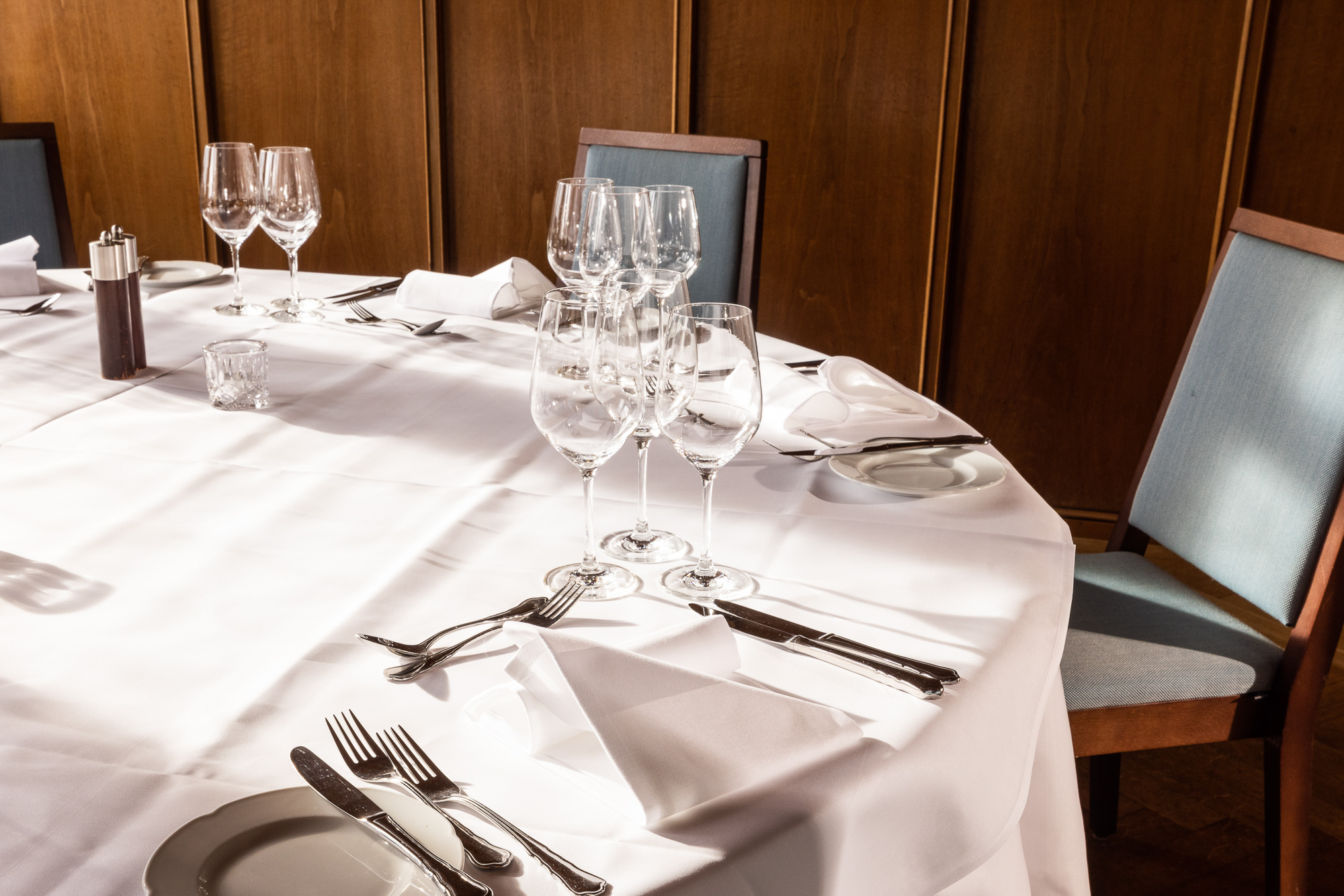 Laid round table with glasses and cutlery in the Waagstübli