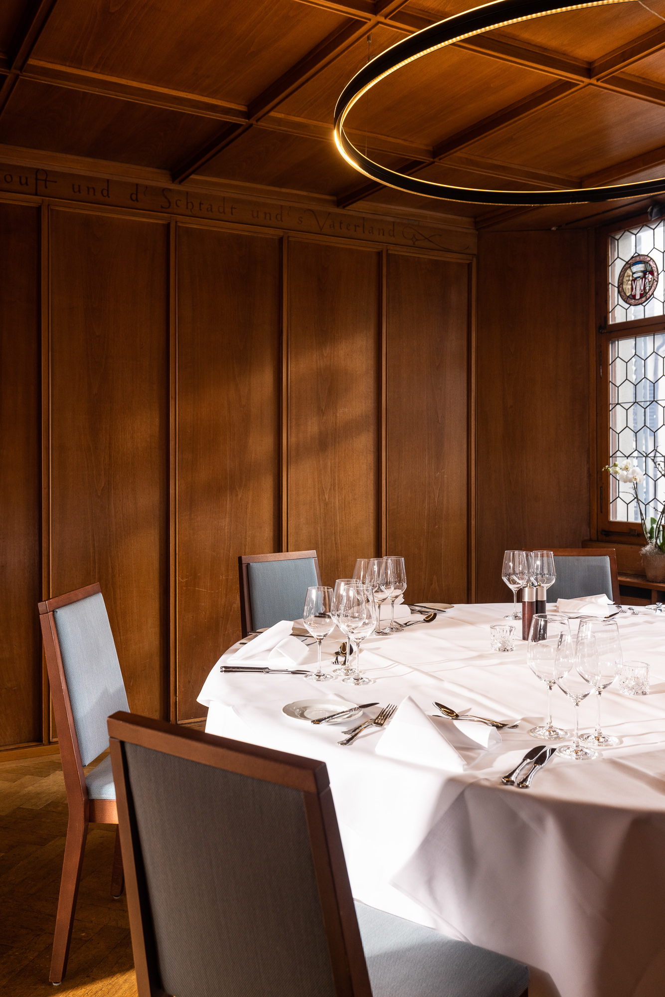 Laid round table against the wood panelling in the Waagstübli
