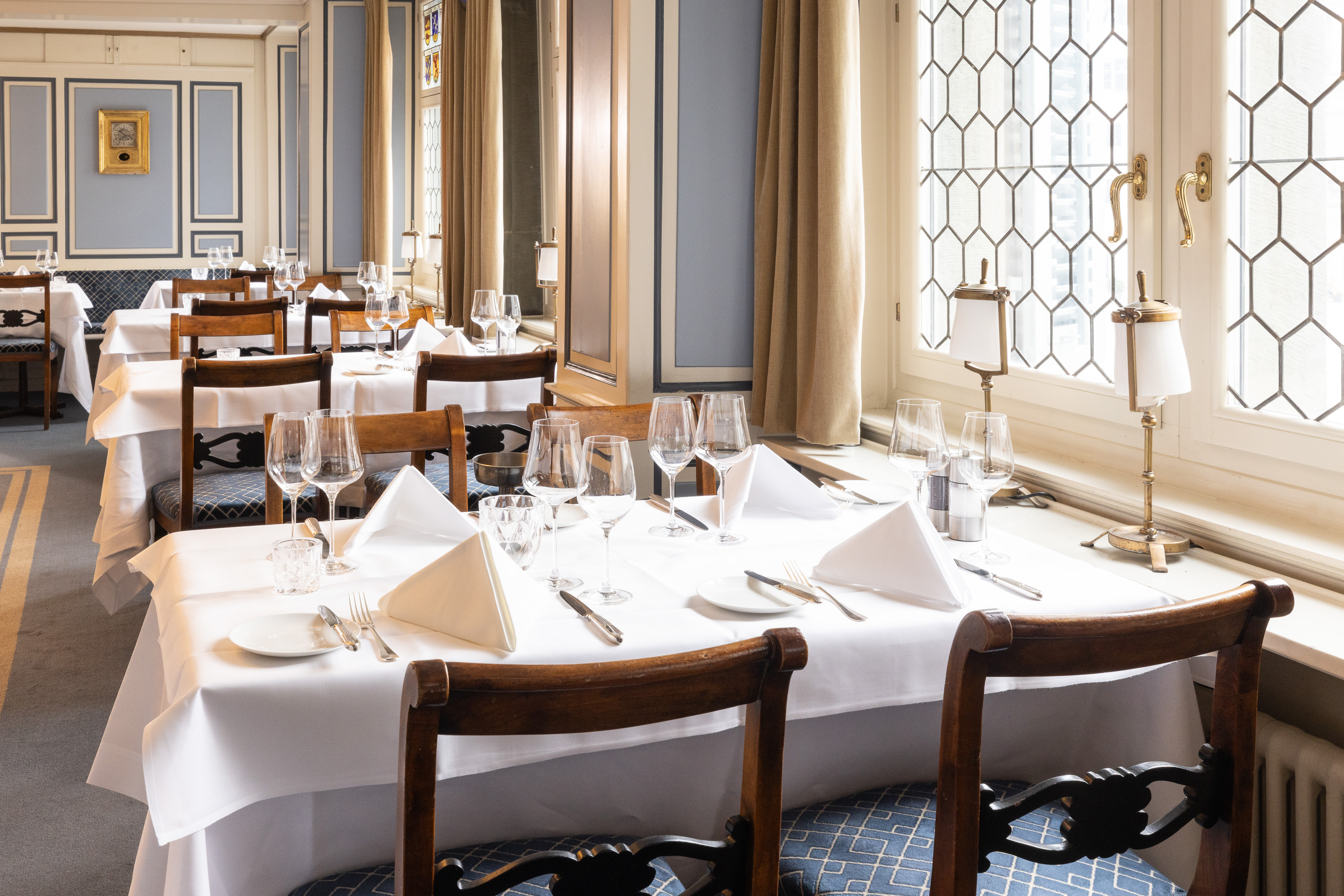 Weiss gedeckte Tische an den Butzenfenstern des Restaurants