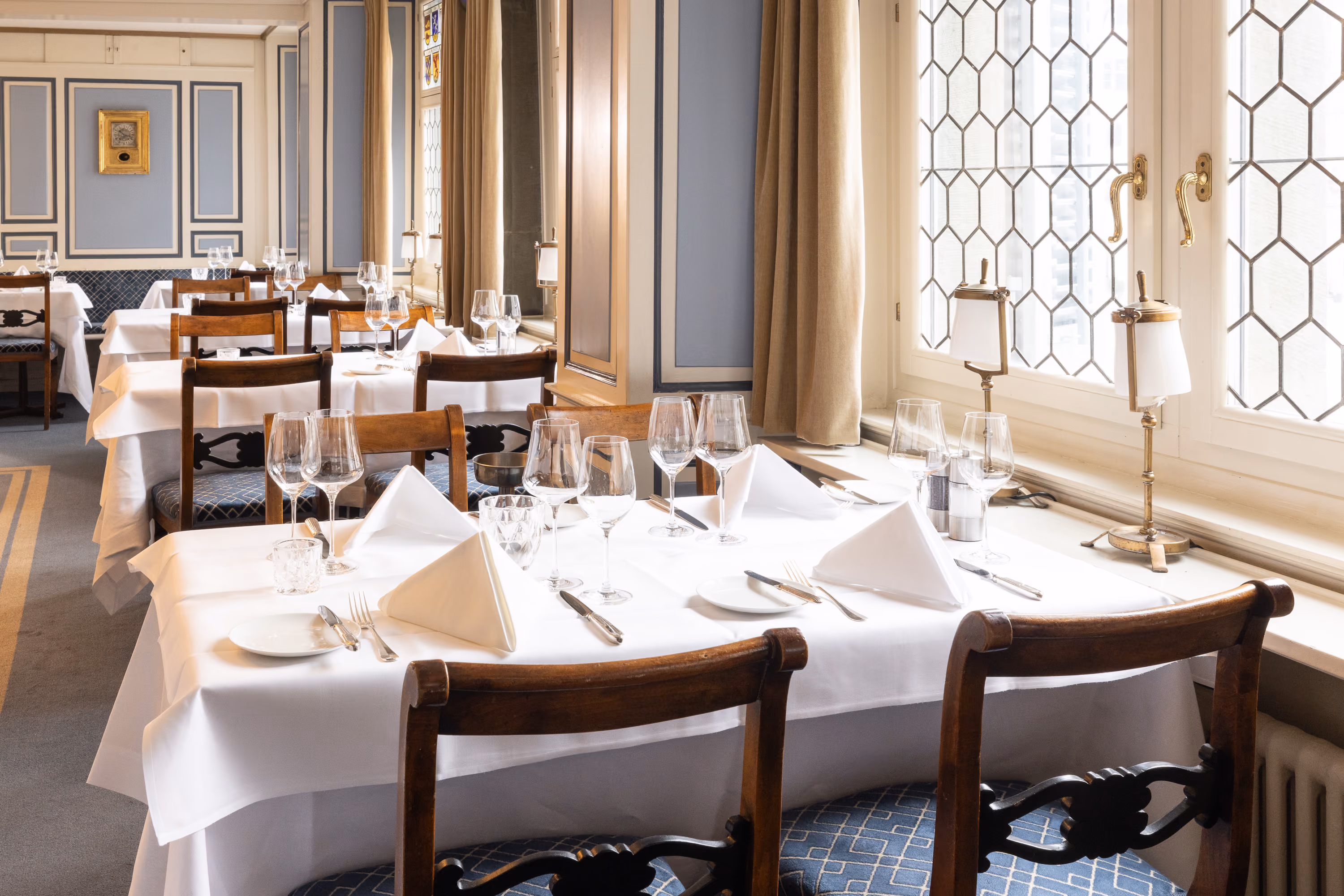 Weiss gedeckte Tische an den Butzenfenstern des Restaurants im Zunfthaus zur Waag