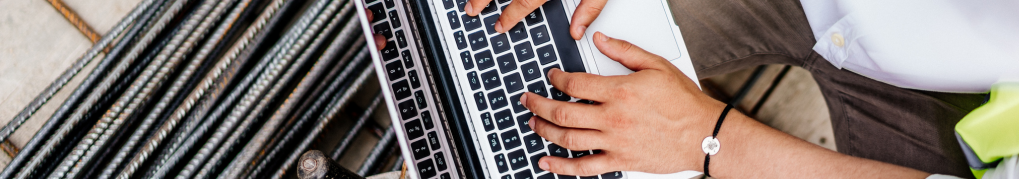image of construction worker typing on MacBook