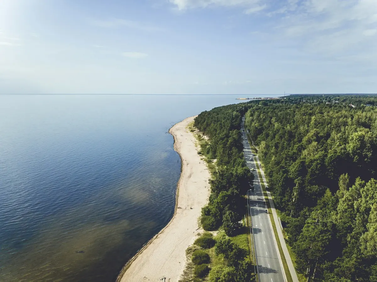 Aerial view of the Baltic Sea coast at Saulkrasti, Latvia, with a sandy beach, pine forest and a coastal road