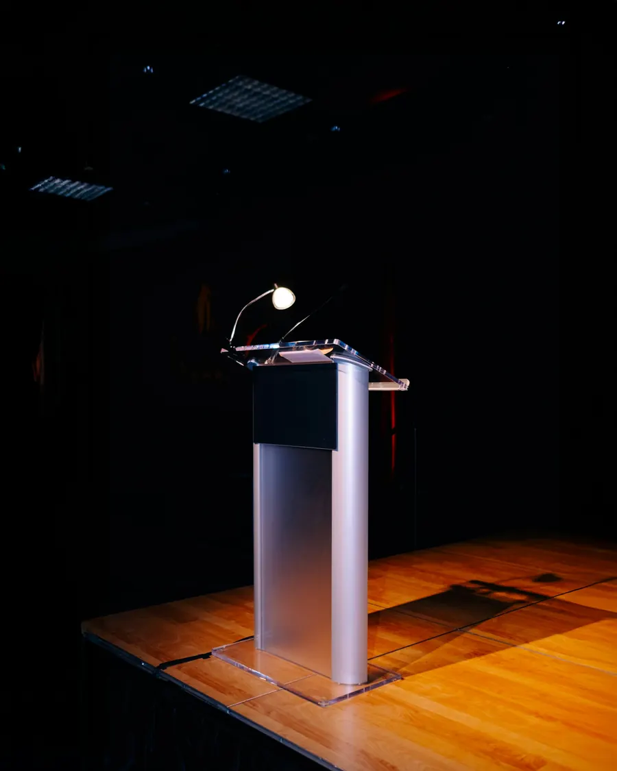 Empty podium with a microphone on a dimly lit stage