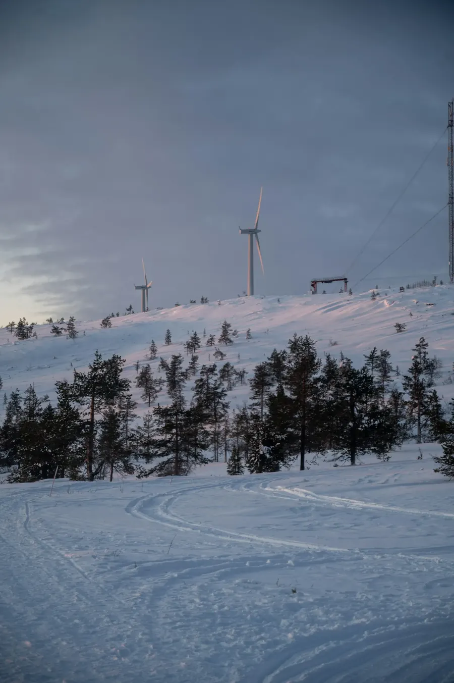 Wind turbines on a snow-covered hill in Finnish Lapland