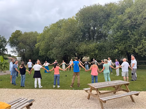 Participants d'un stage de Dama Healing réunis en cercle dans un jardin
