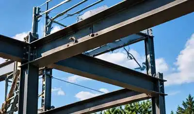 Structural steel frame installation on construction site with blue sky background