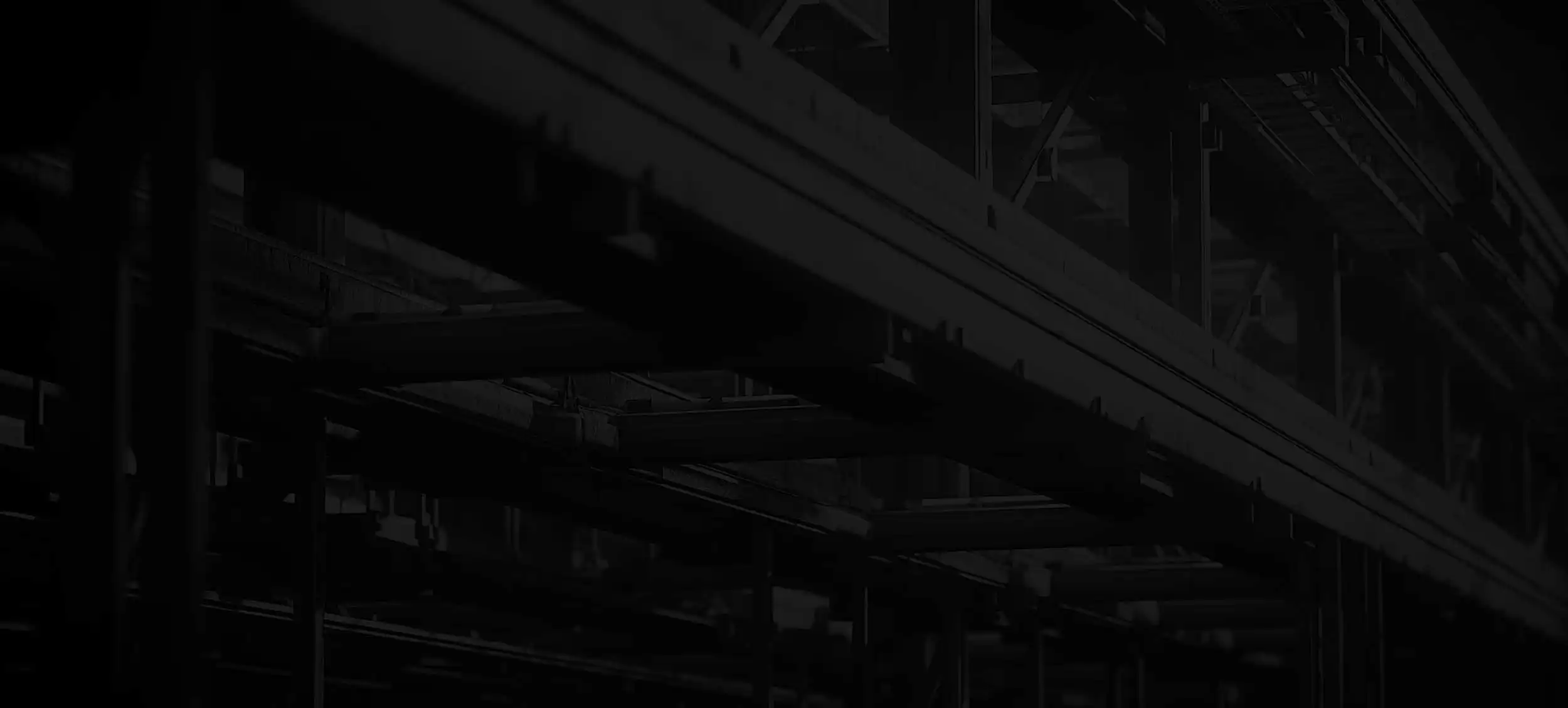 Dark industrial construction site with steel beams and scaffolding structure under low lighting, creating a moody and dramatic background for construction theme