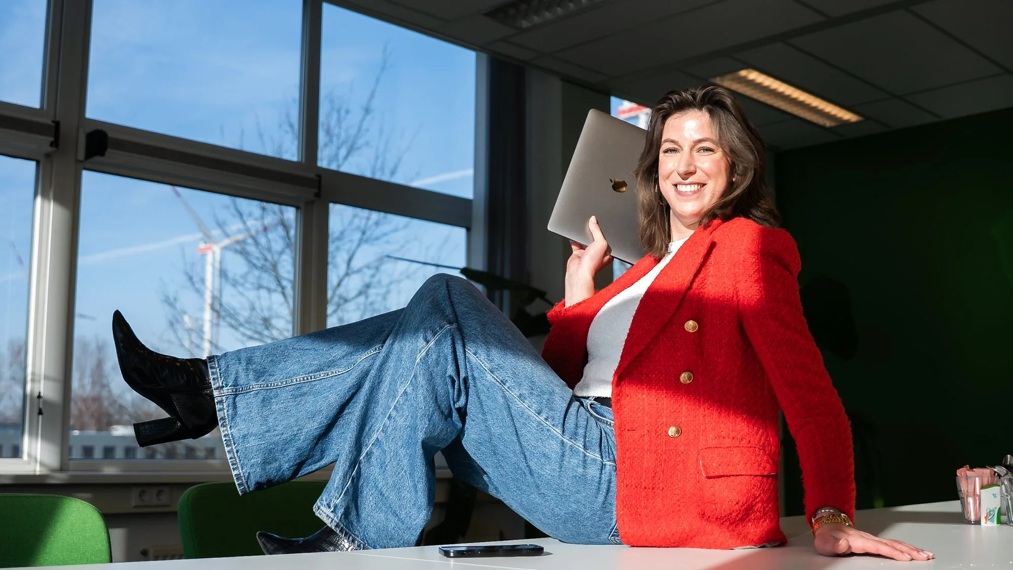 Amber, Creative at Pro Contact, with her laptop in the office