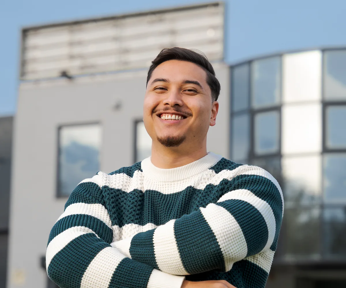 Mauro, advertising specialist, met gekruiste armen voor het kantoor van Pro Contact