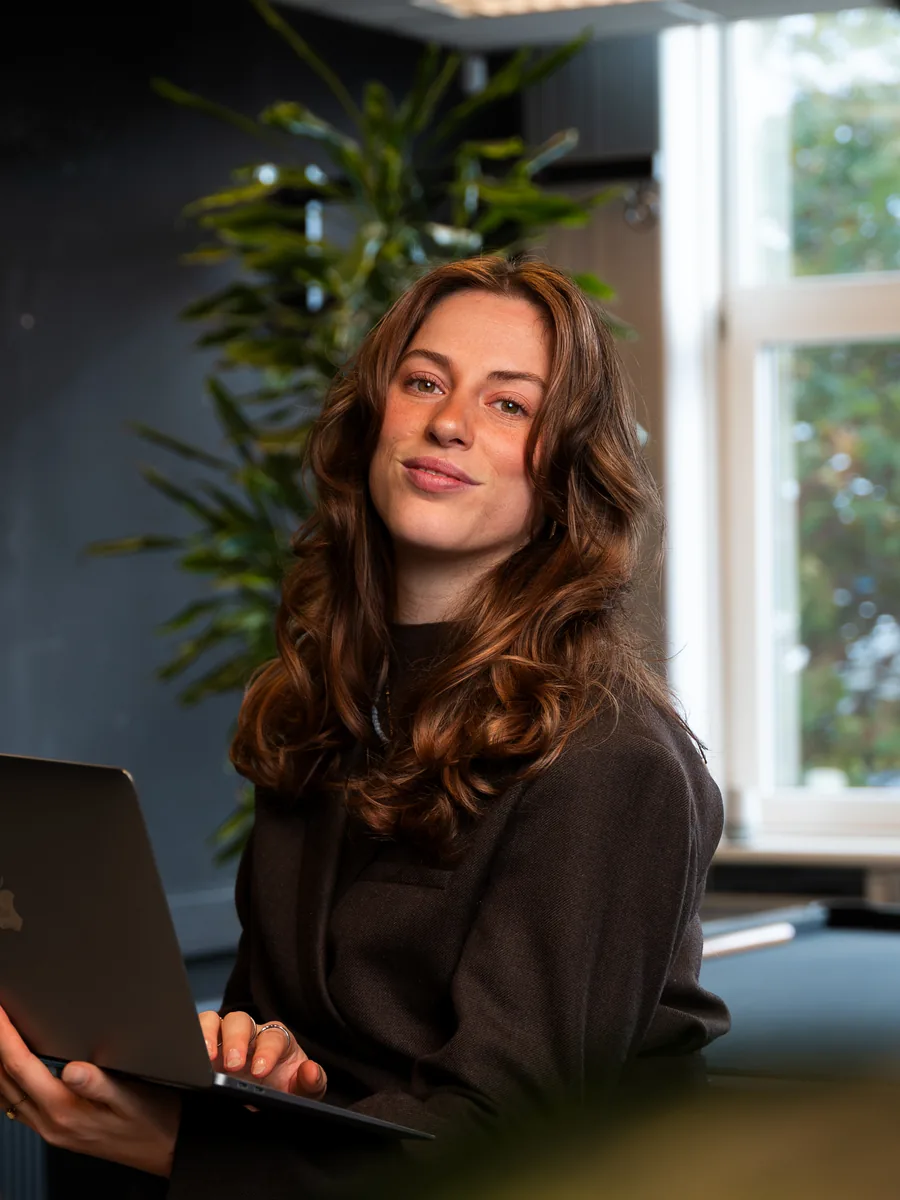 Aniek, recruitment consultant, met laptop op kantoor