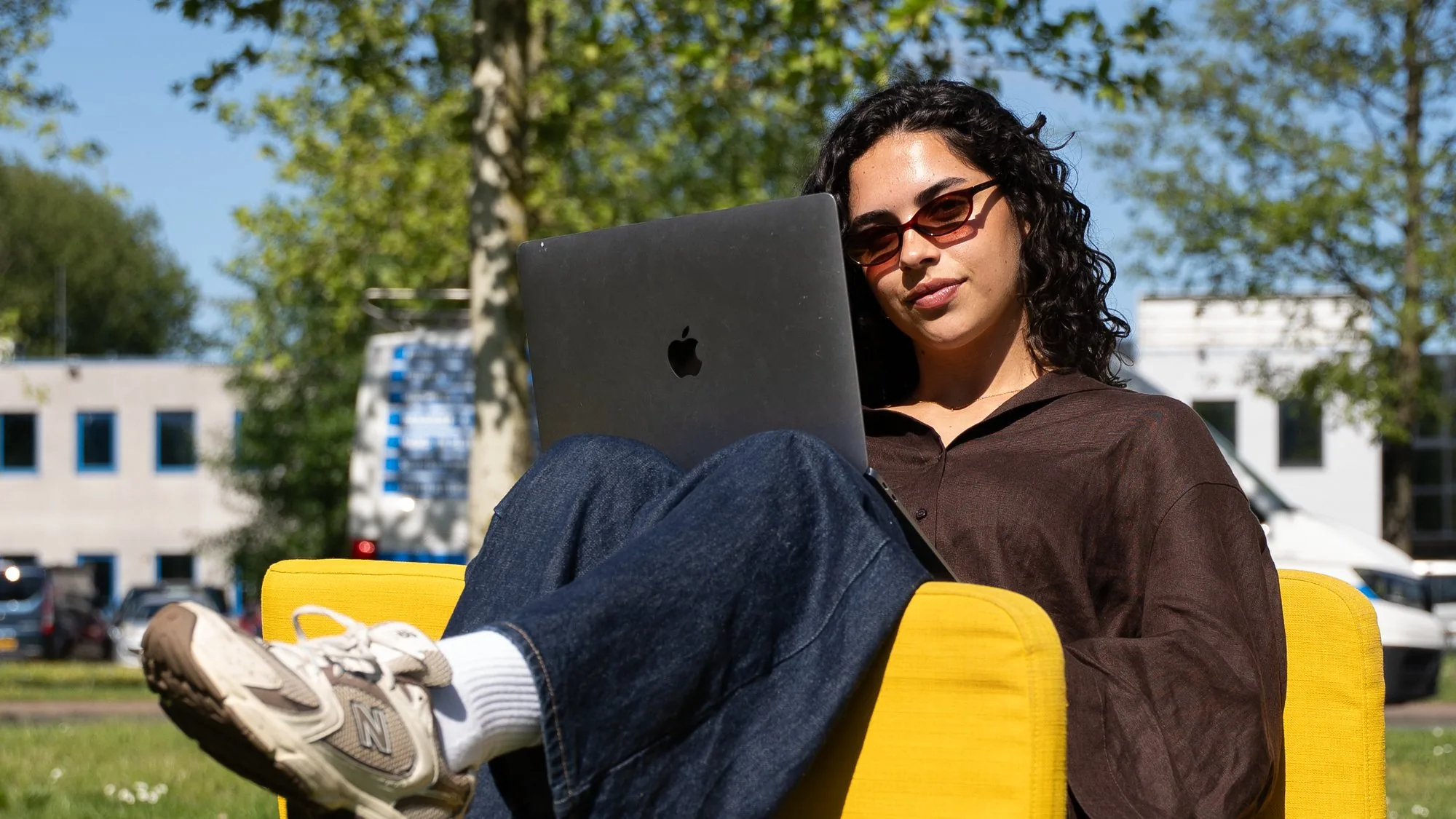 Izara, Creative at Pro Contact, working outside on her laptop