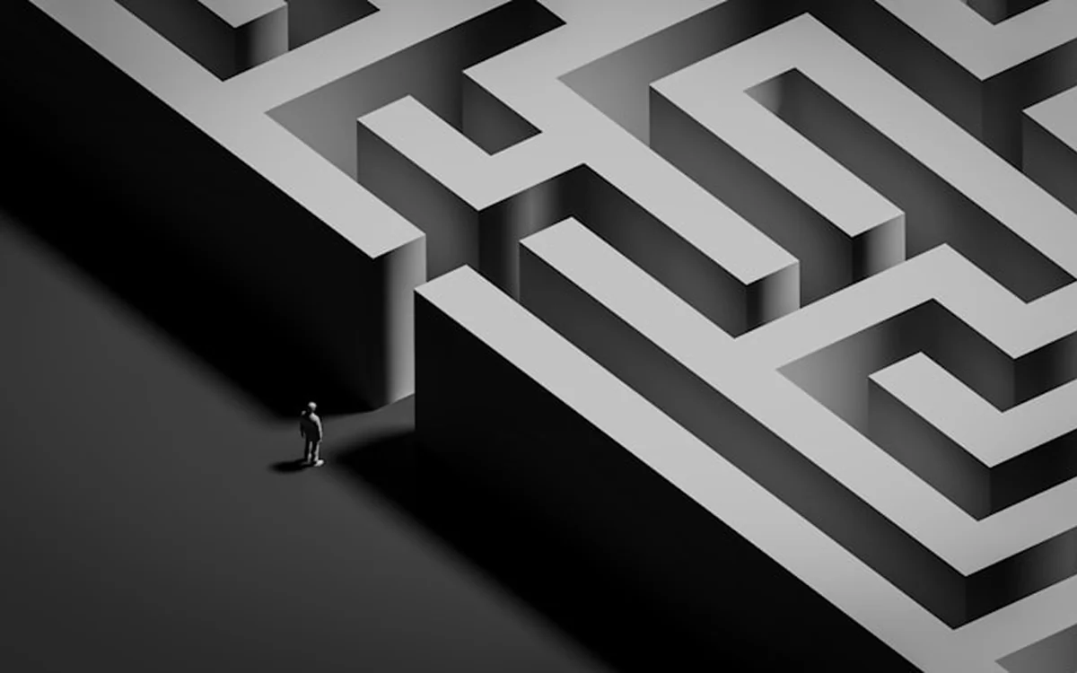 Lone figure at the entrance of a grey maze