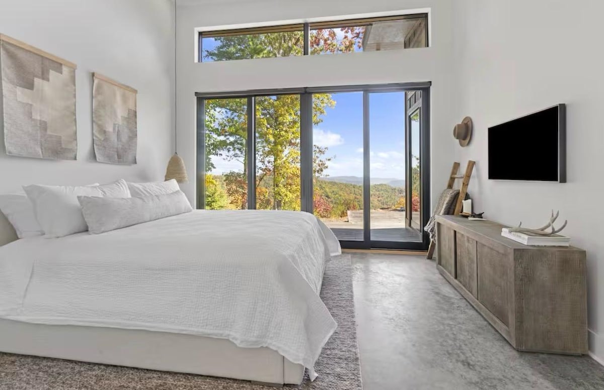 King suite with a sliding glass door opening onto the deck and long mountain views