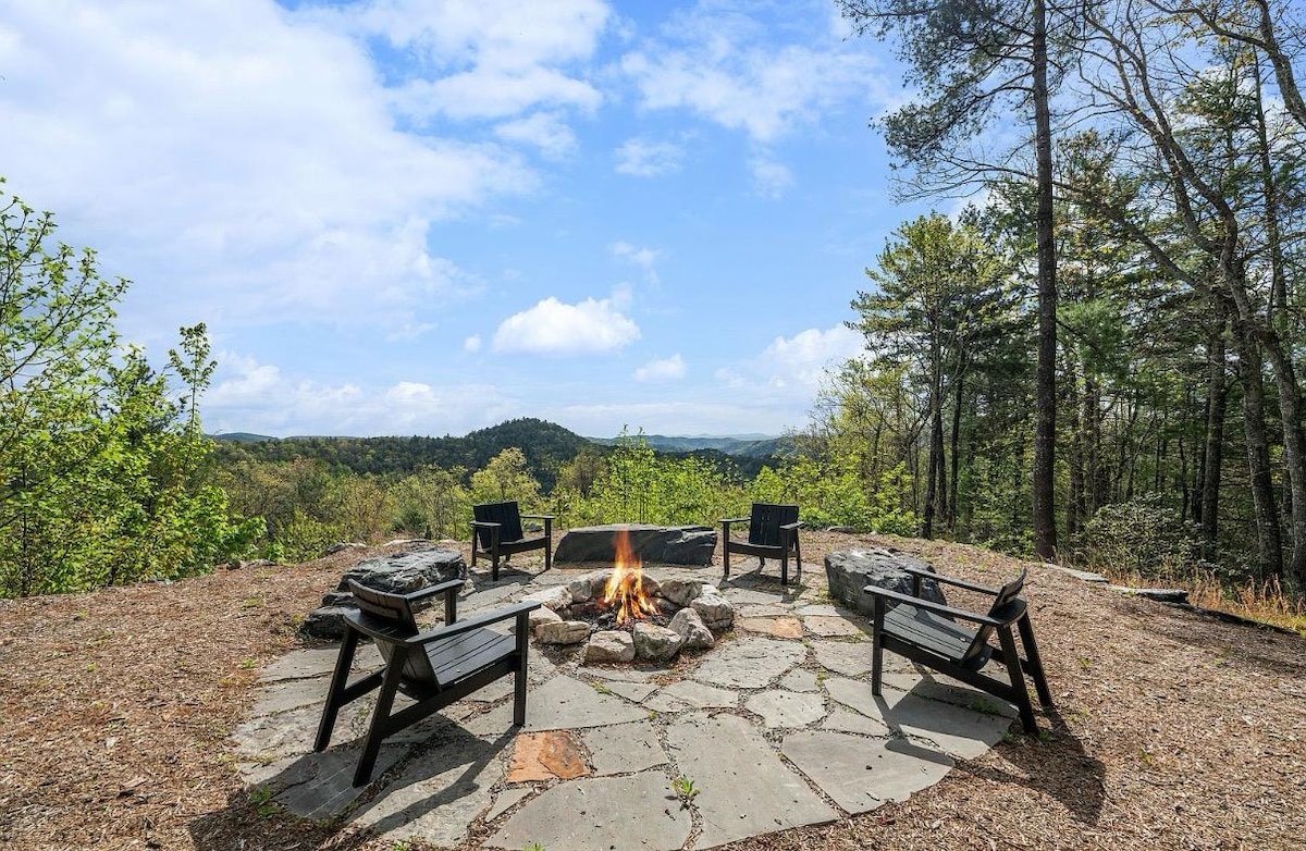 Stone fire circle on the ridge with Adirondack chairs facing the mountains