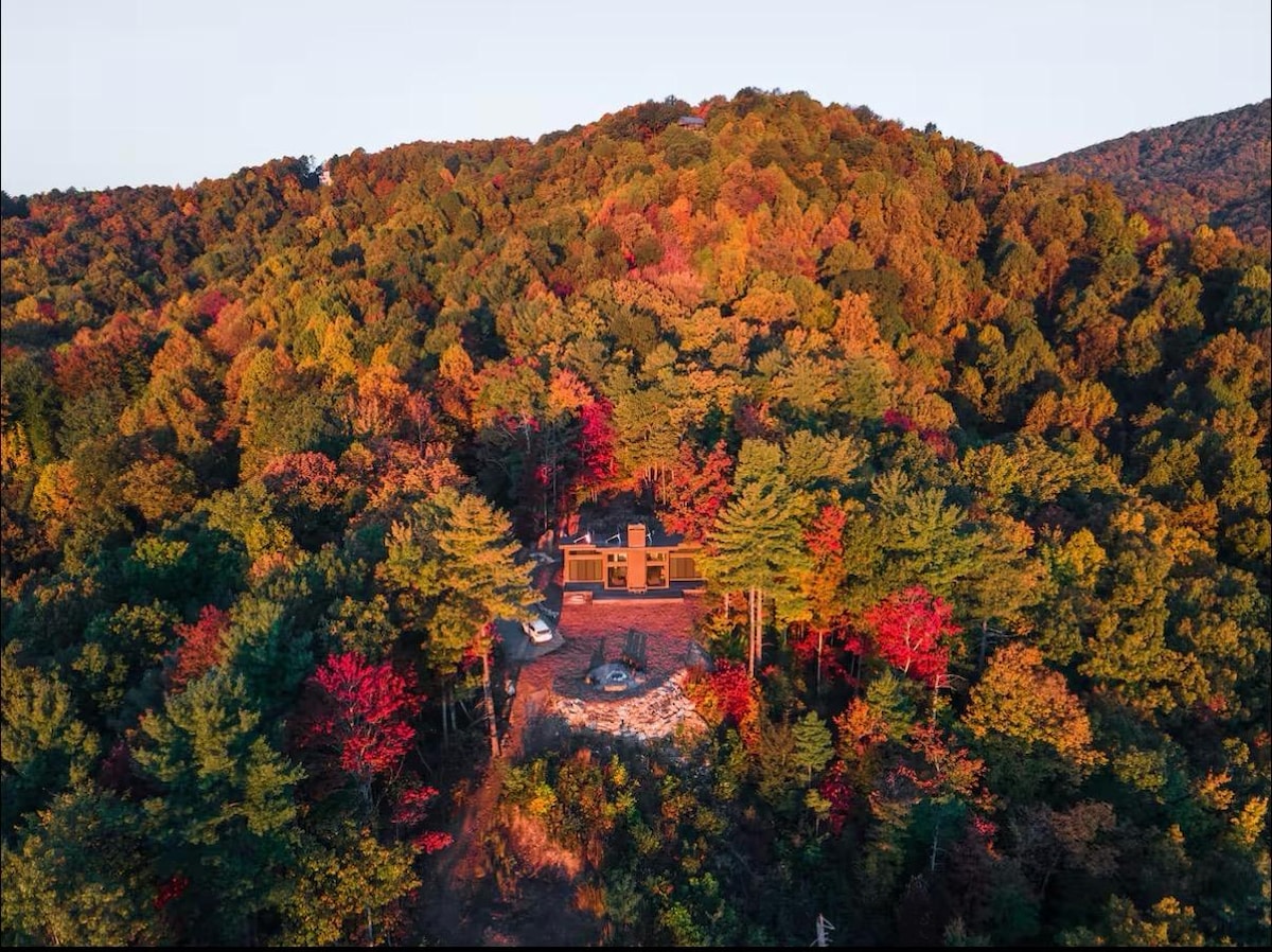 Aerial view of the cabin surrounded by ten acres of autumn forest at sunset