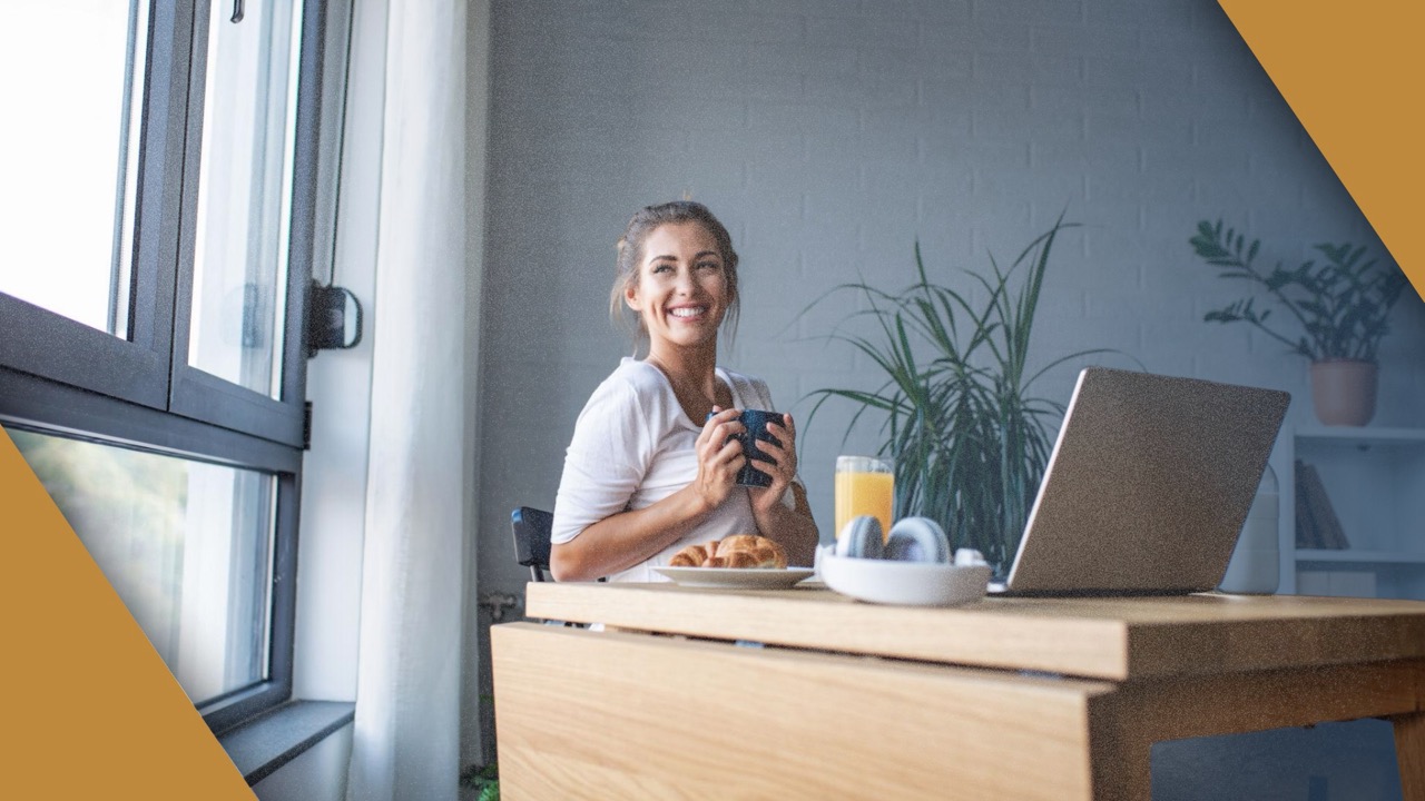 A mid-career woman in an olive blouse, in window light.