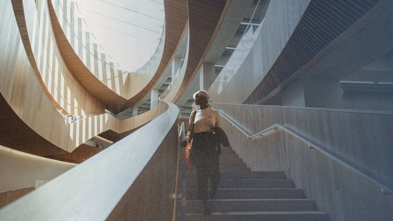 A person walking down a modern wooden staircase in a bright atrium.