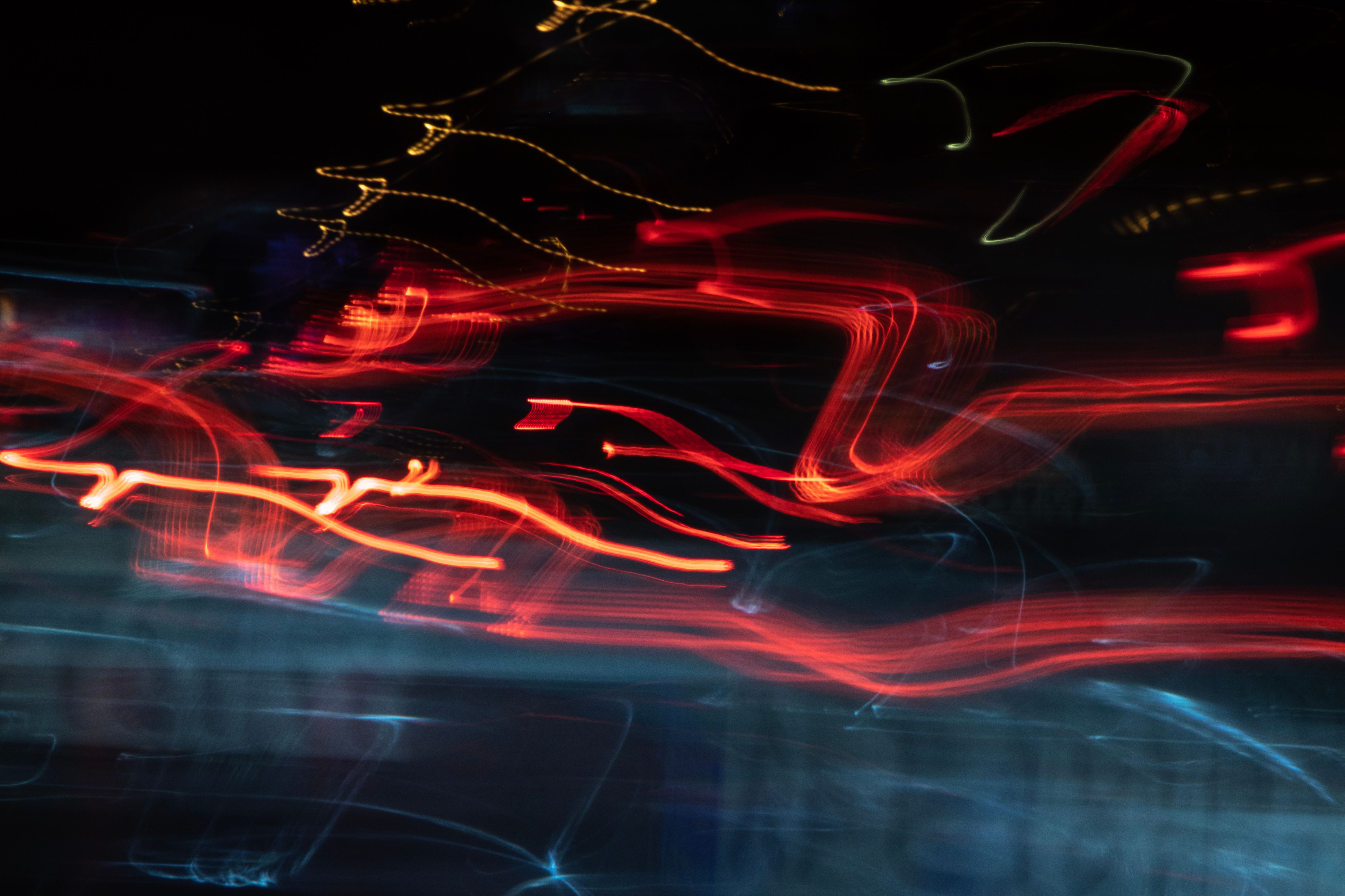 Strands of orange and blue light crossing in the dark, representing direct current flowing through an AI data center