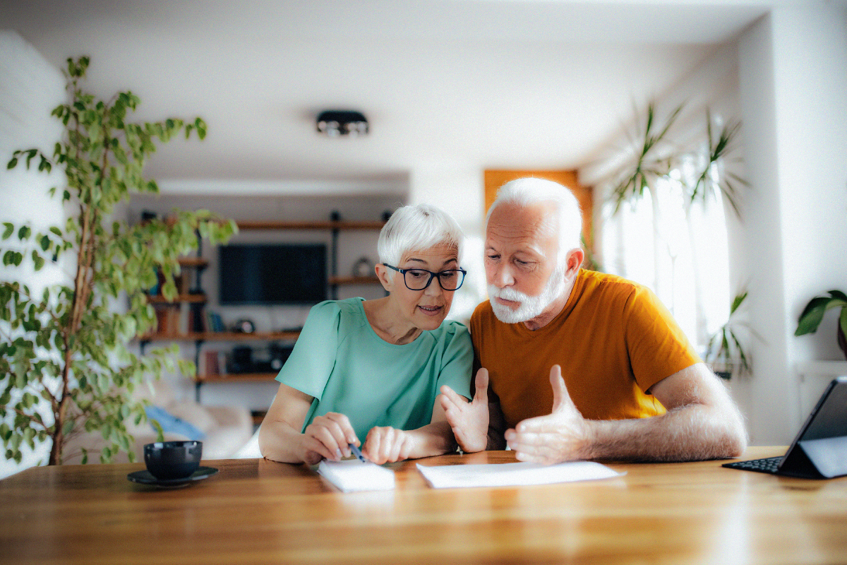 Adult daughter and her parents writing in a planning notebook