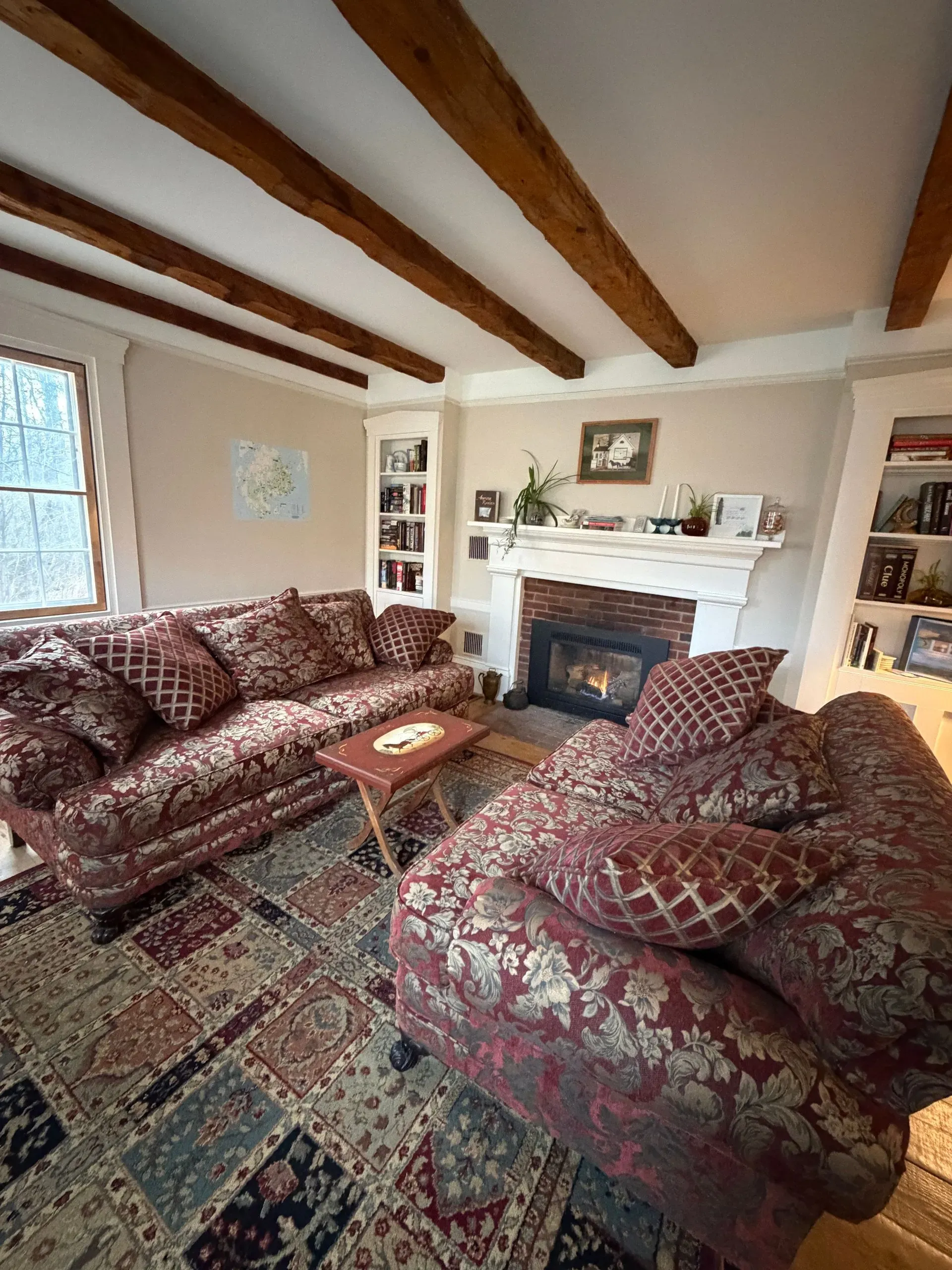 Parlor with fireplace and exposed beams at Coach Stop Inn
