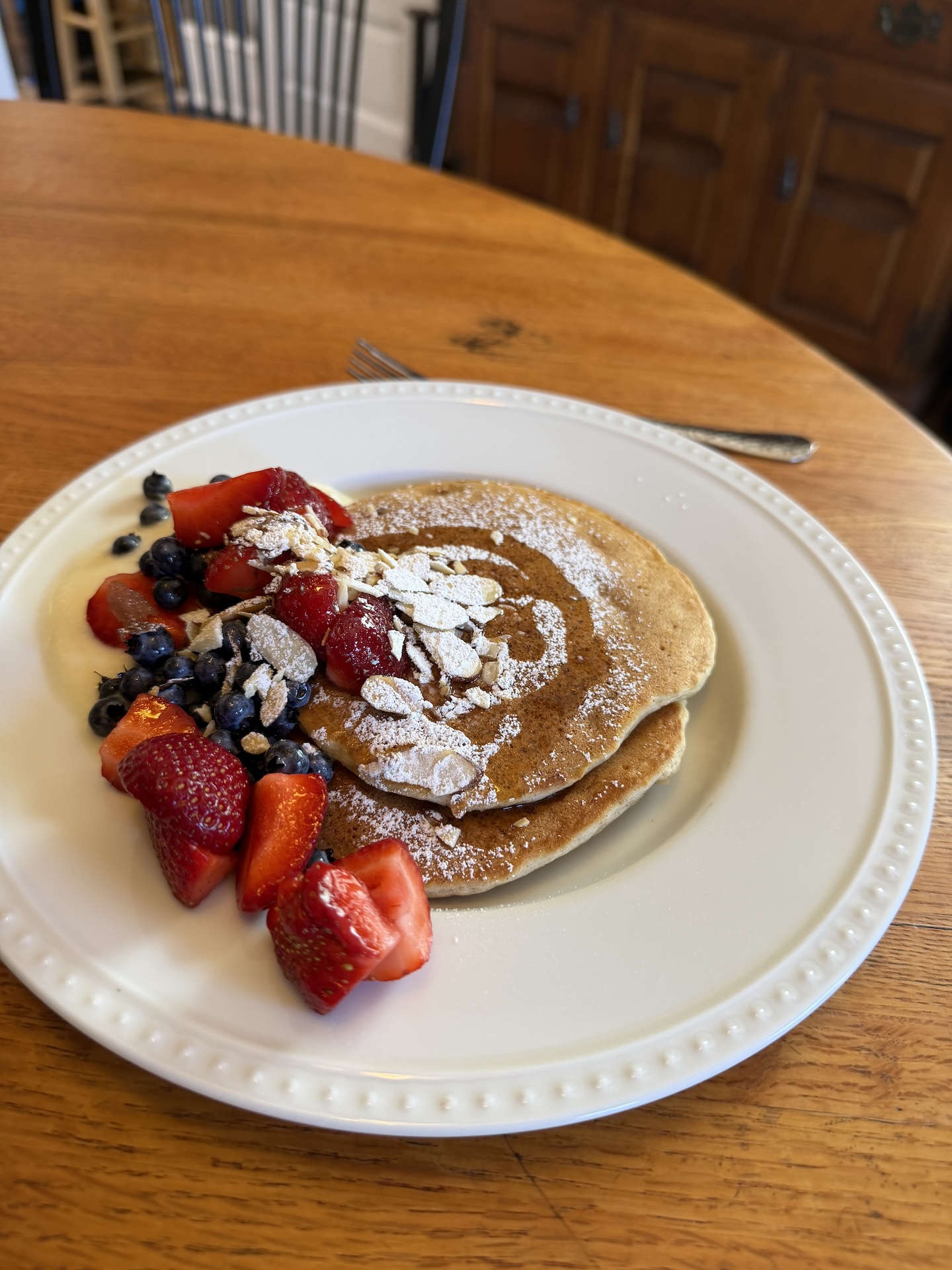 A photo of a plate with pancakes and strawberries
