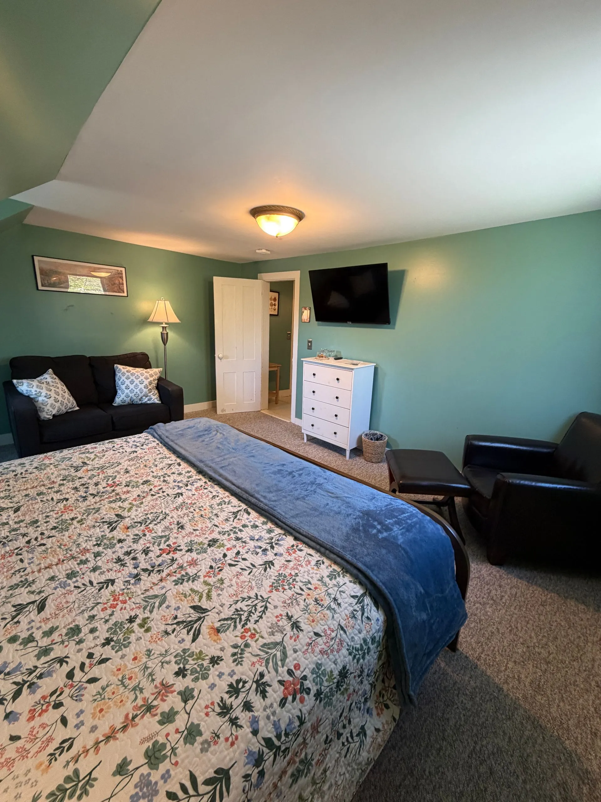 Acadia bedroom with king bed, seating, and TV at Coach Stop Inn