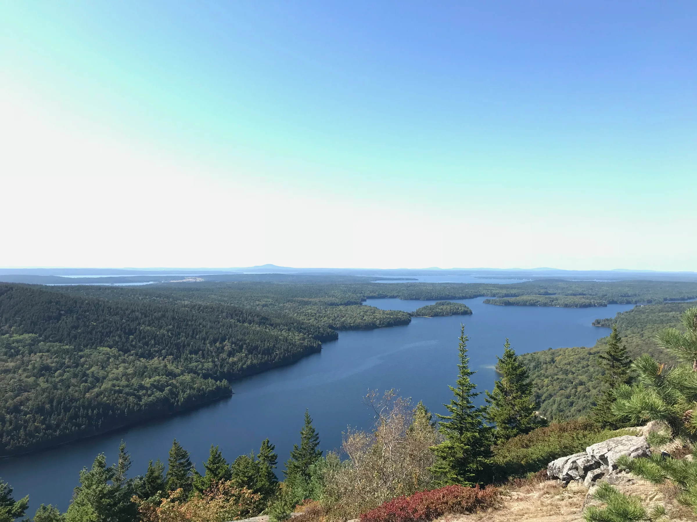 A view from atop a mountain looking out over a large lake