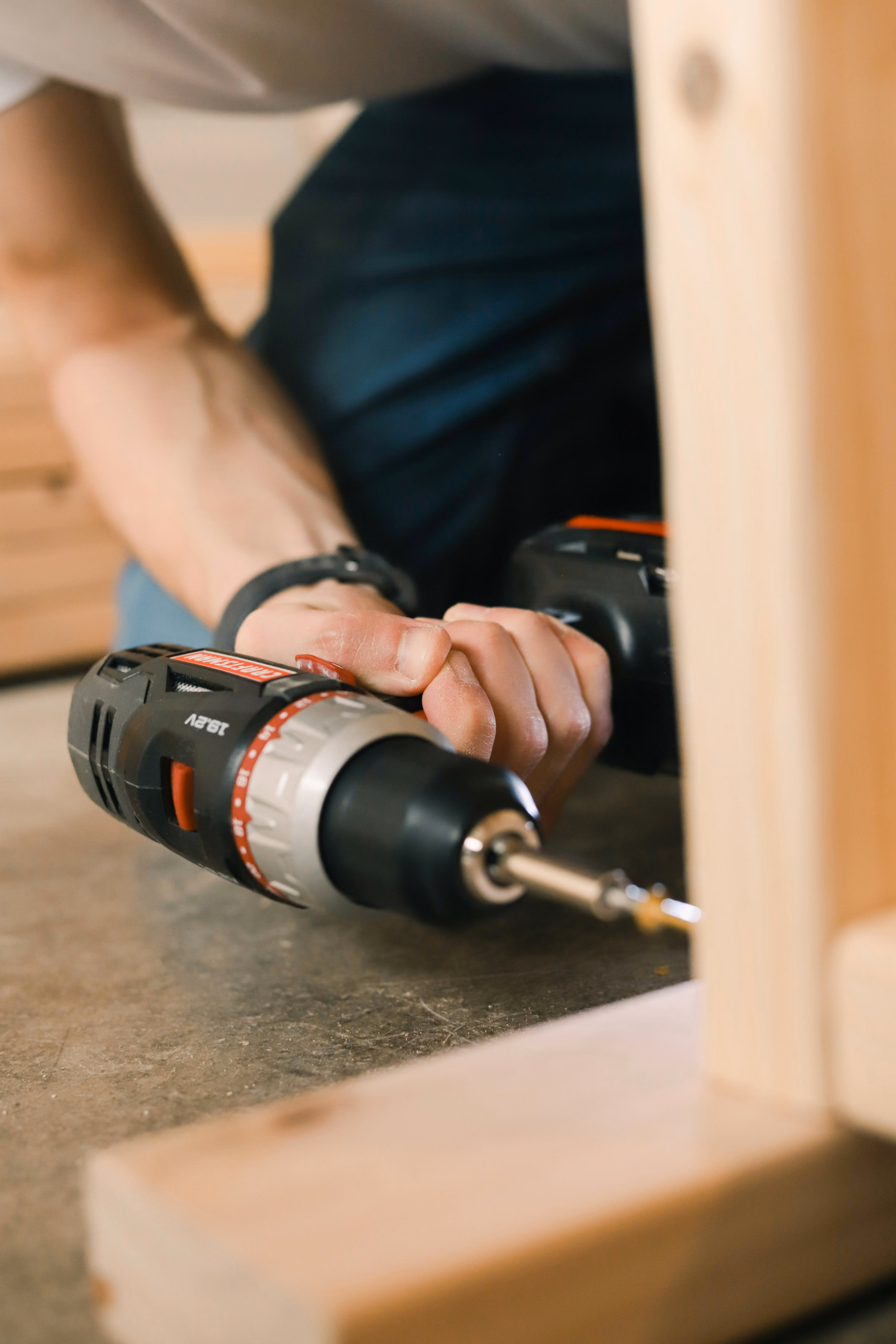 Handyman assembling furniture with a power drill