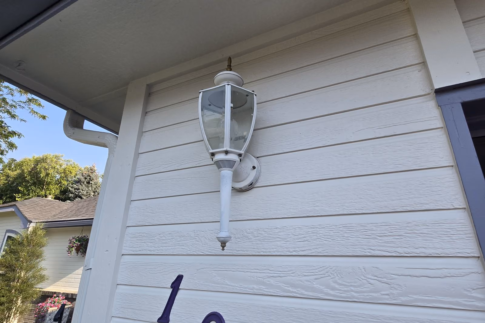 Old white porch light on siding