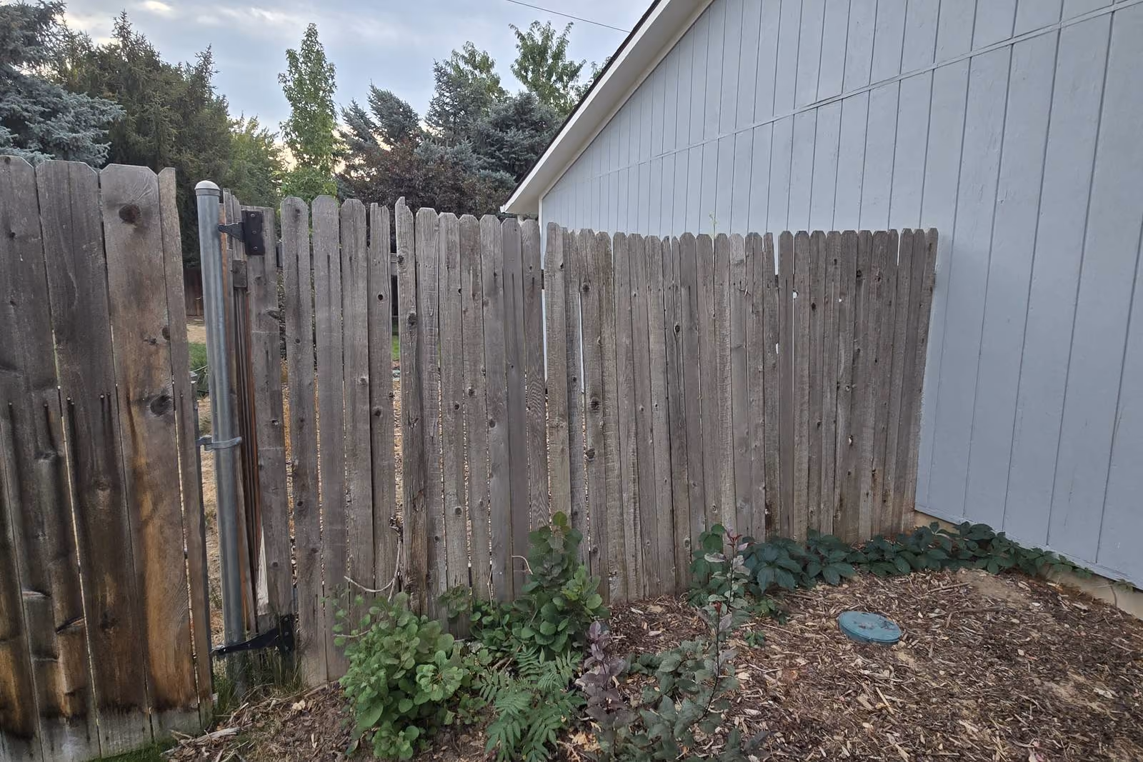 Old gray wood fence beside a house