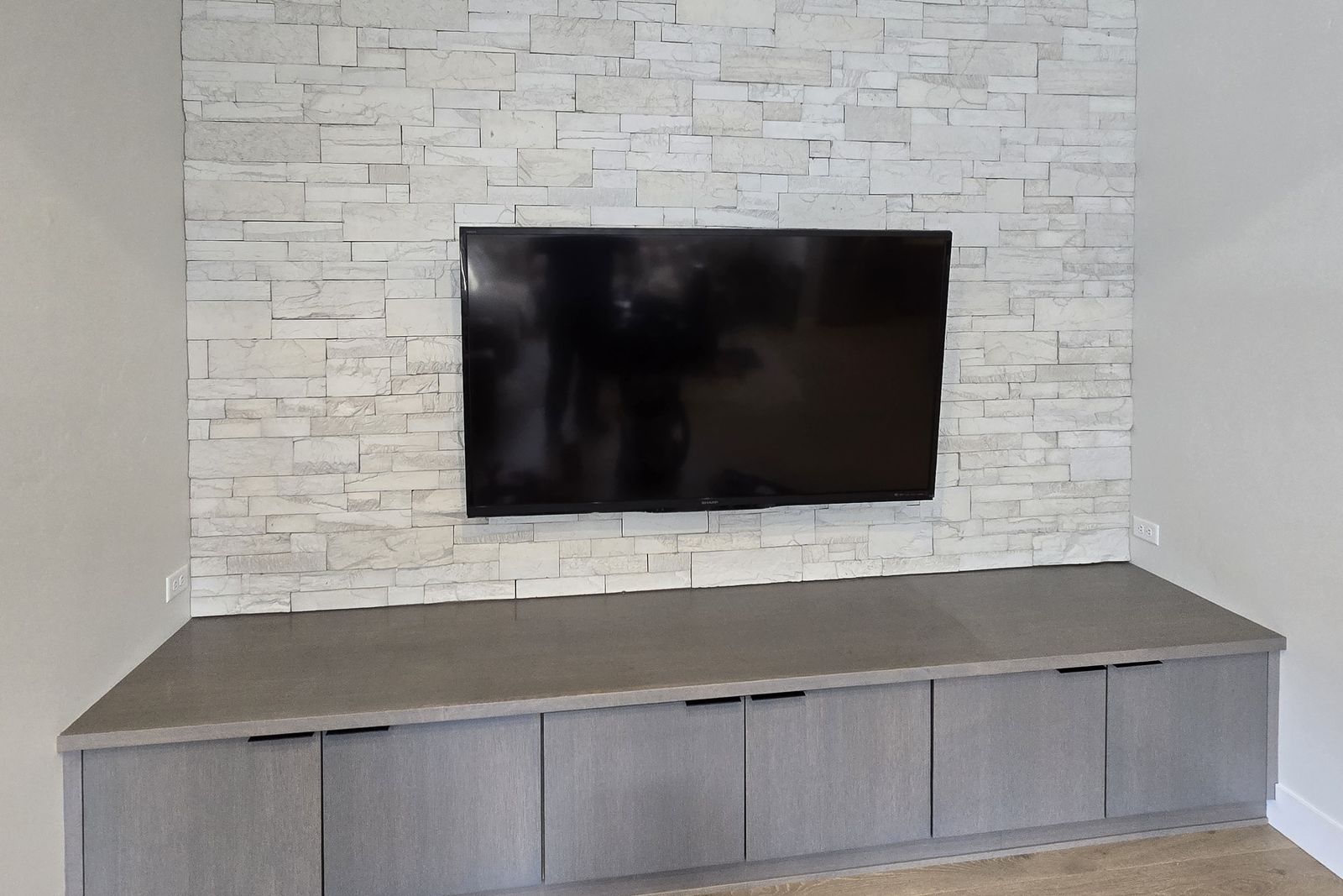 Flat-screen TV mounted above a stone fireplace