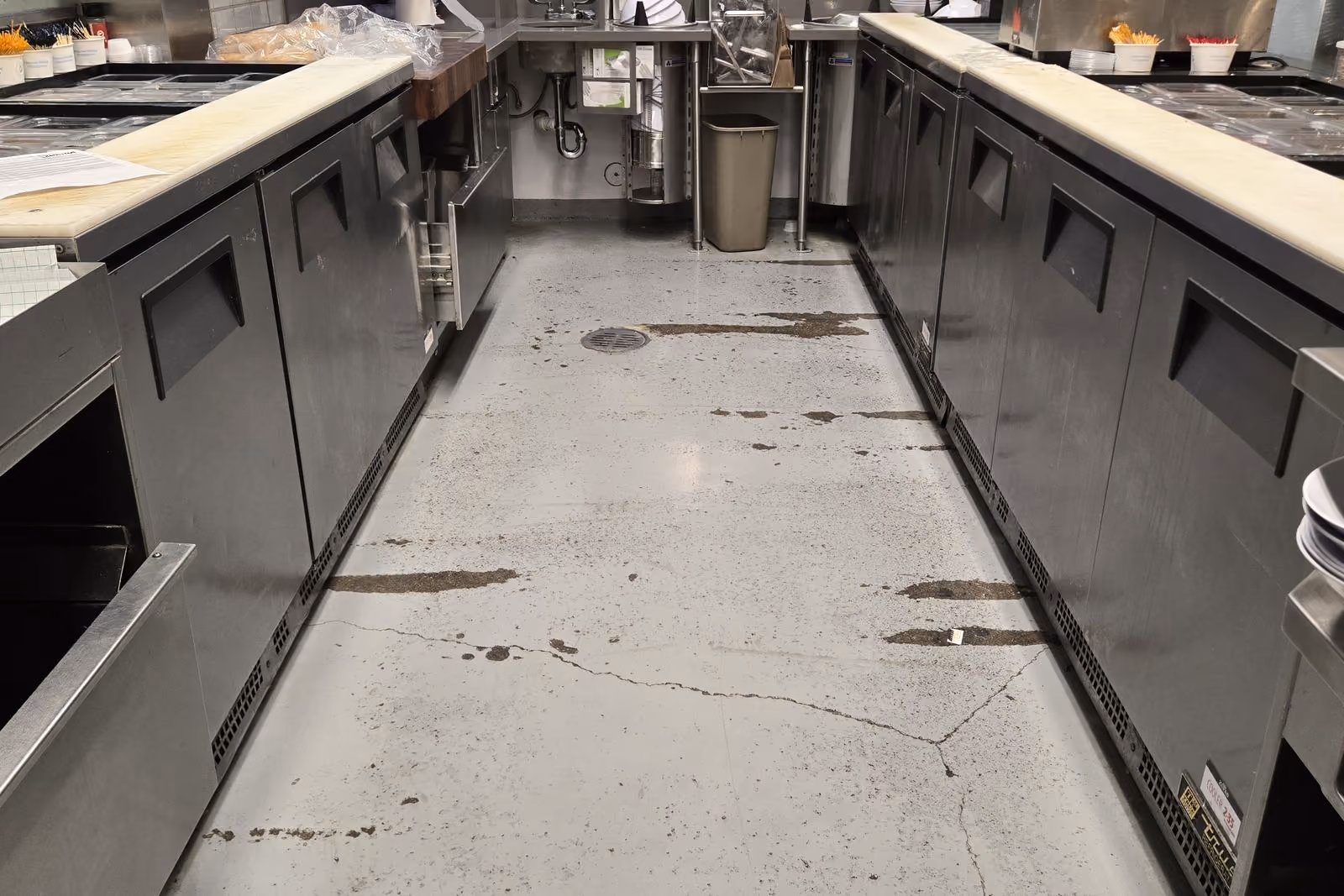 Commercial kitchen floor before: stained, cracked concrete