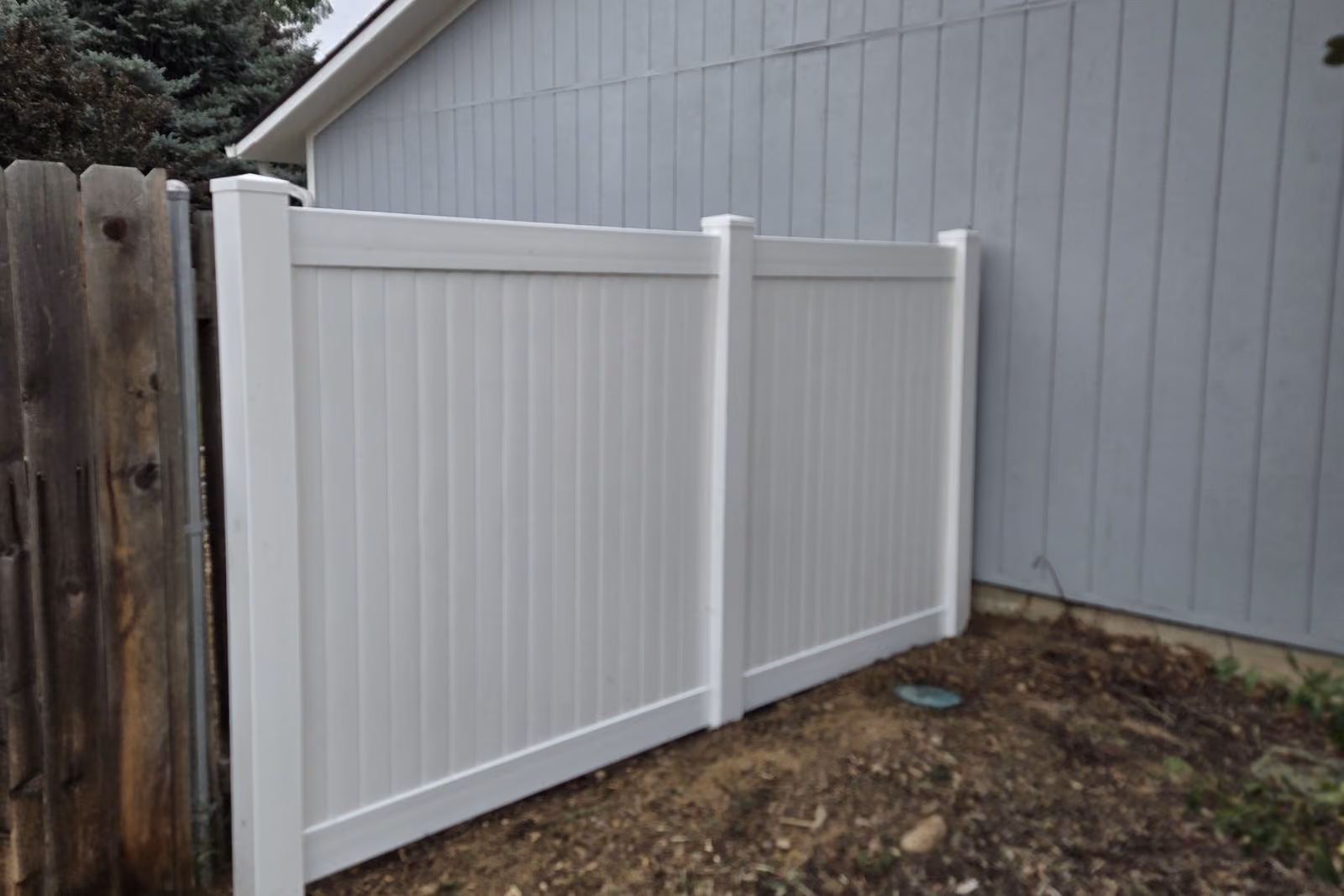 White vinyl privacy fence installed alongside a Treasure Valley home