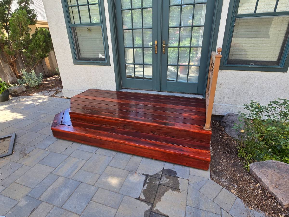 The same deck steps after refinishing, with a deep red stain