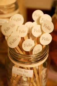 Mason jar of cocktail stirrers tagged Feliz