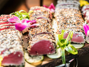 Sesame-crusted seared ahi tuna slices garnished with orchids