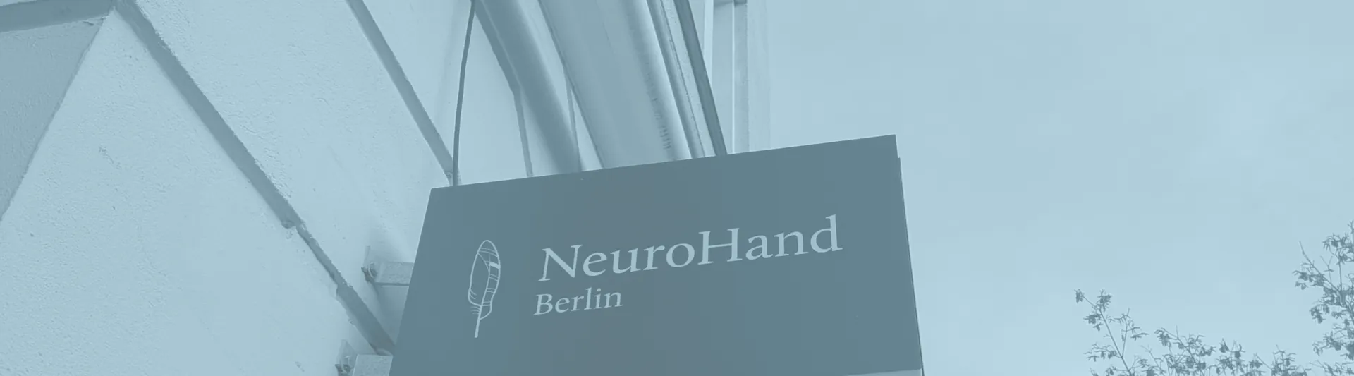 Praxisschild NeuroHand Berlin am Fenster