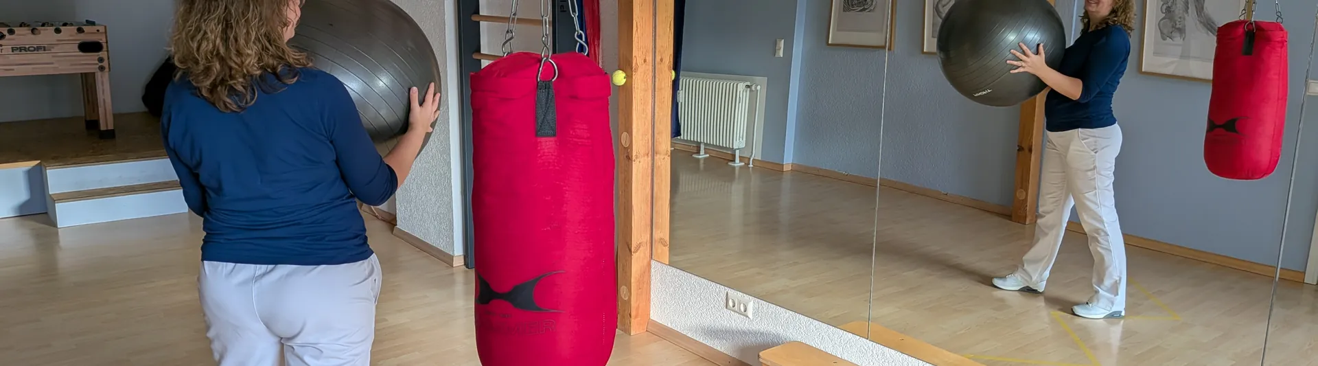 Übung mit einem Gymnastikball im Bewegungsraum