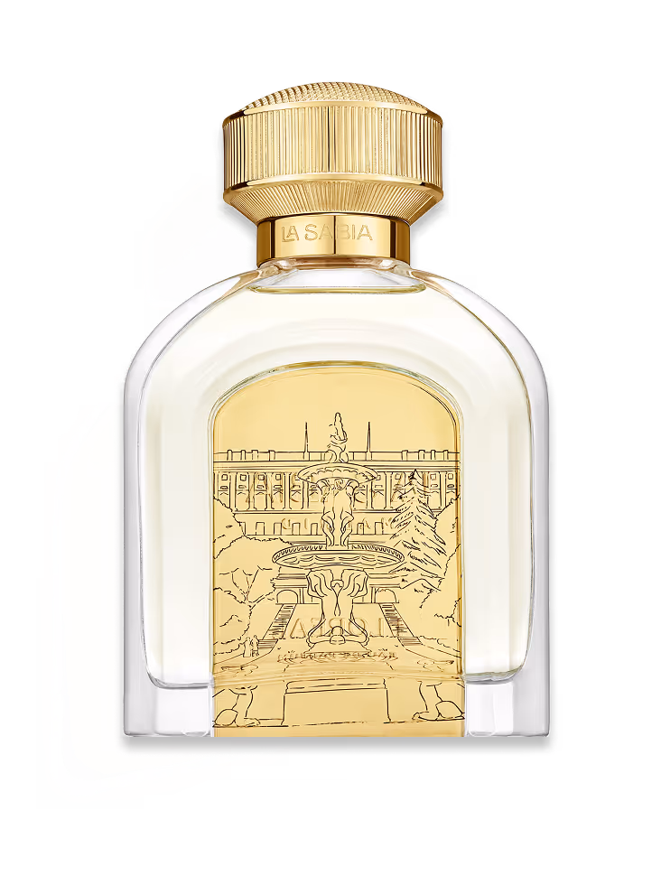 Transparent perfume bottle with gold cap and a gold plaque engraved with a fountain and building scene.