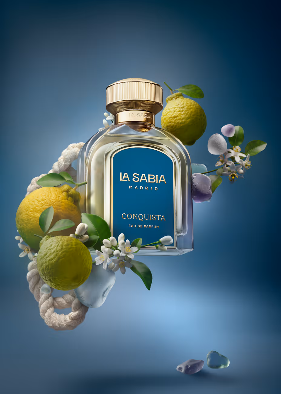 La Sabia Madrid Conquista perfume bottle surrounded by lemons, flowers, rope, and crystals on blue background.