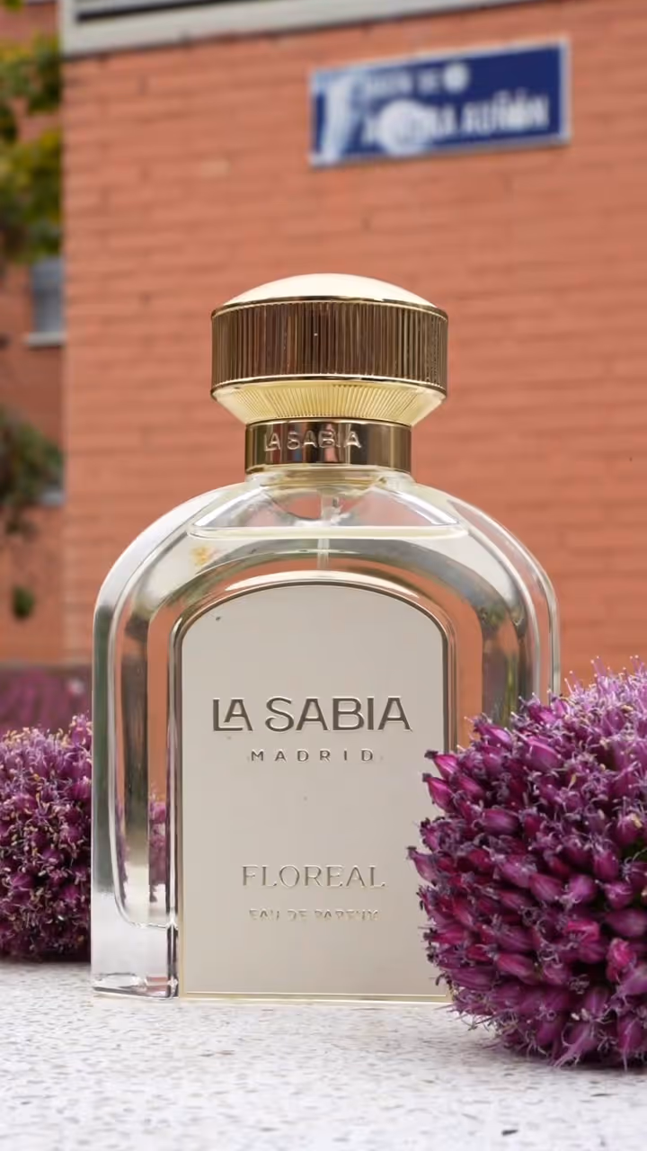 La Sabia Madrid Floreal perfume bottle with gold cap and purple flowers on white surface.