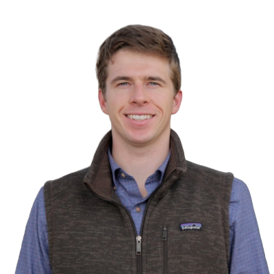 Smiling young man with short brown hair wearing a blue button-up shirt and a dark brown zip-up vest.
