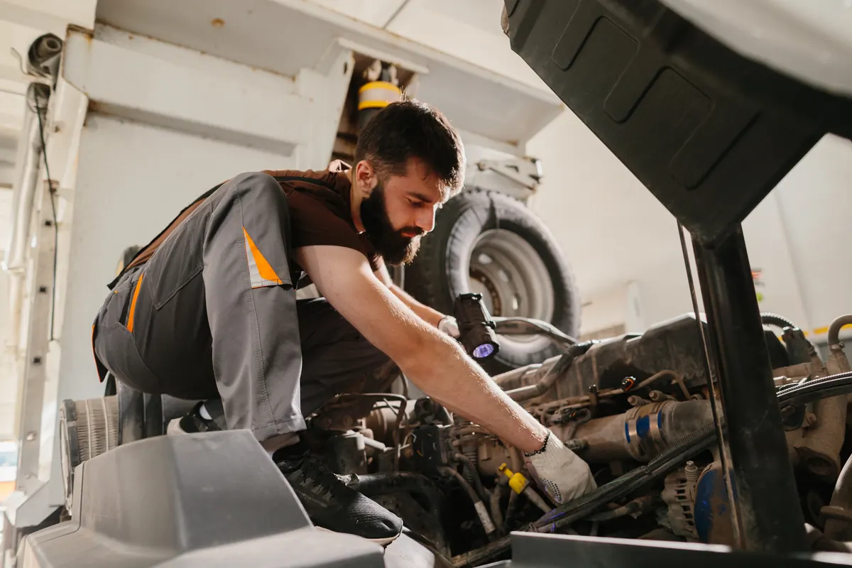 Mechanic inspecting and repairing a commercial truck engine