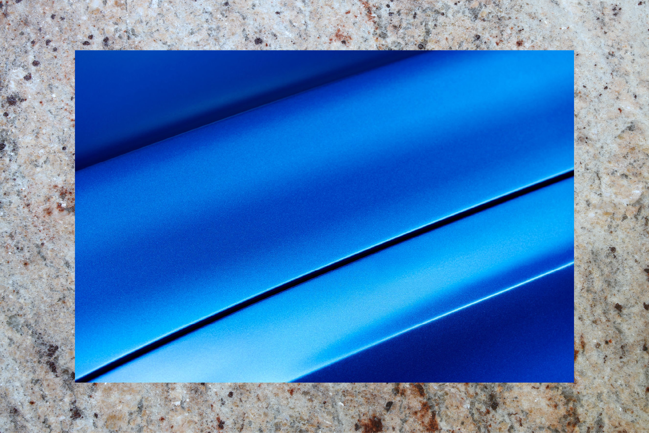 A car body panel in deep blue