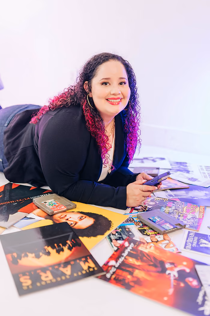 Kristine Gonzalez holding a Game Boy in her studio