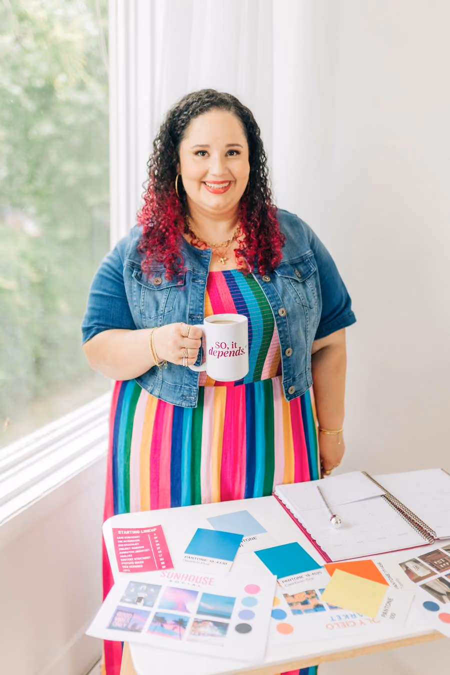 Kristine Gonzalez holding a mug by a window.